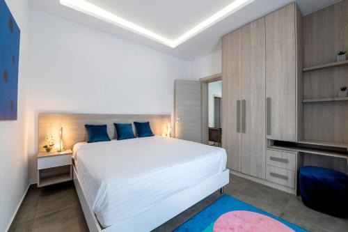 a bedroom with a large white bed with blue pillows at M Mansion in Pefki Rhodes