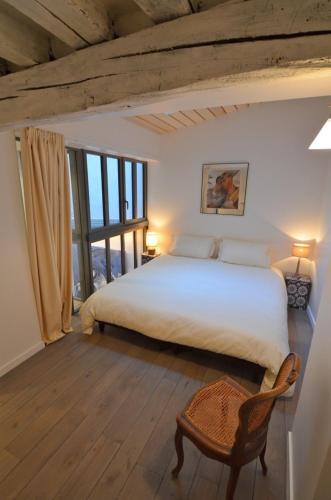 une chambre avec un grand lit blanc et une fenêtre dans l'établissement La Table, à Paris