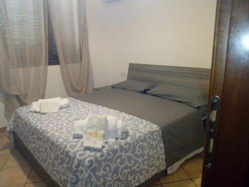 1 dormitorio con 1 cama con mesa y toallas en The Sandalia House en Olbia