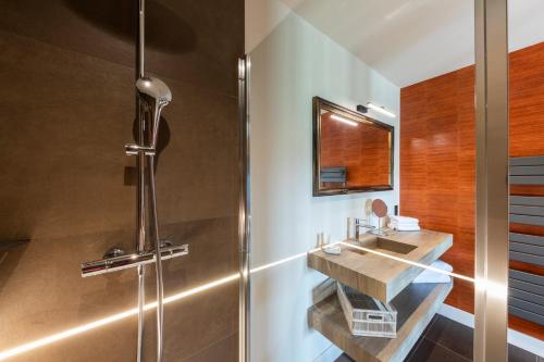 een badkamer met een wastafel en een douche bij Hôtel Villa Alexandre in Régnié