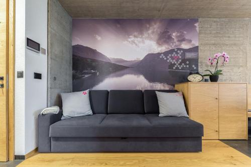 a living room with a couch and a painting of a lake at Hiša Križaj in Bohinj