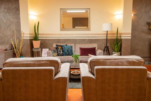 a hotel room with three beds and a couch at Hotel Carignano in Lucca