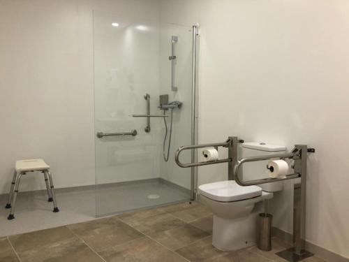 a bathroom with a toilet and a glass shower at Casa Rural La Calzada in El Payo