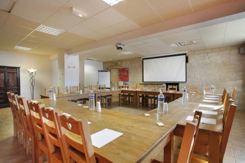 une grande salle de conférence avec une grande table et des chaises dans l'établissement La Pradella, à Bolquère-Pyrénées 2000