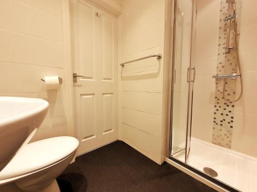 a bathroom with a shower and a toilet and a sink at The Maynard in Scarborough