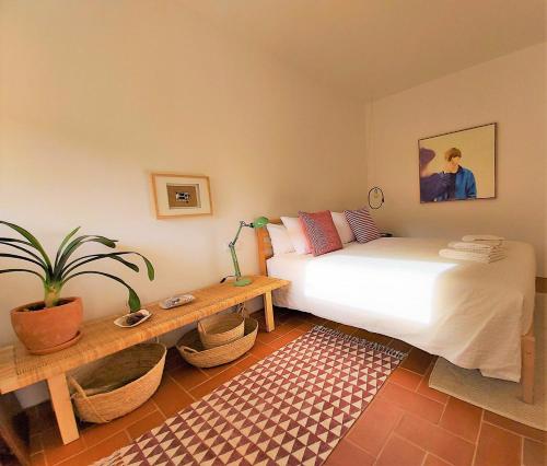 a bedroom with a bed and a table and a plant at Architect Arts Elegant Villa in Tavira