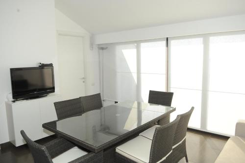 a dining room with a glass table and chairs at The Roof On The Sea in Fondachello
