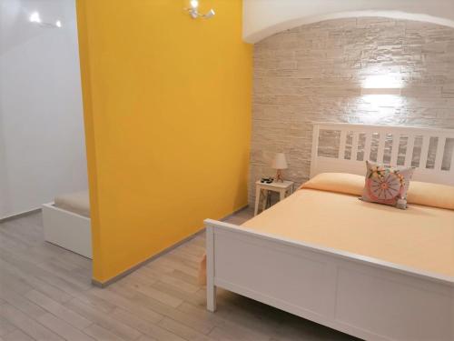 a bedroom with a bed and a yellow wall at DG Sicily in Catania