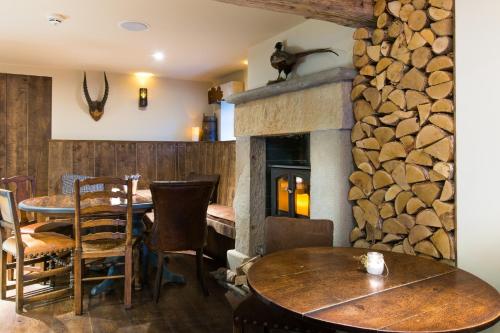 a dining room with a table and a stone fireplace at Barley Mow in Burnley