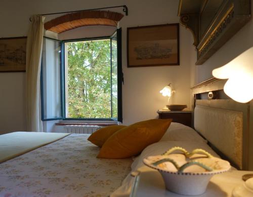 a bedroom with a bed with a window and a bowl of bread at Bella di Ceciliano in Arezzo