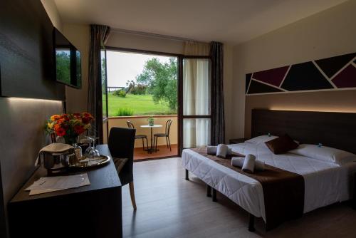 une chambre d'hôtel avec un lit, une table et une fenêtre dans l'établissement Hotel Carignano, à Lucques