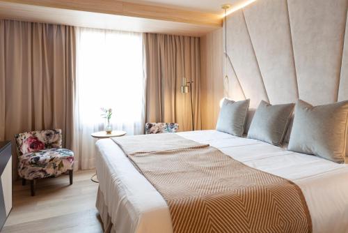 a hotel room with a large bed and a chair at Nivia Born Boutique Hotel in Palma de Mallorca