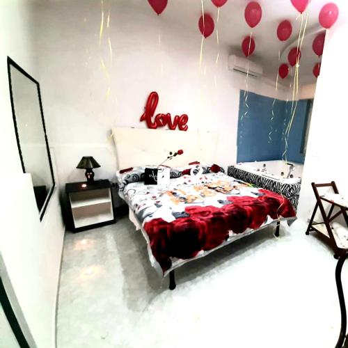 a bedroom with a bed with a love sign on the wall at Hotel Napoleon-Cuore in Qualiano