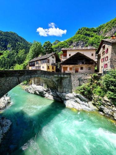 a bridge over a river with buildings on it at River and Mounts in Campertogno