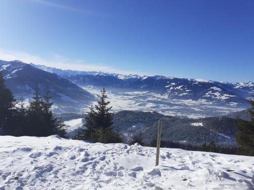 a snow covered hill with mountains in the background at Gasthof Hubertus in Saalfelden am Steinernen Meer
