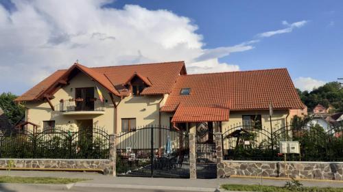 a house with a fence in front of it at Casa Raisa & Maria in Ocna Sibiului