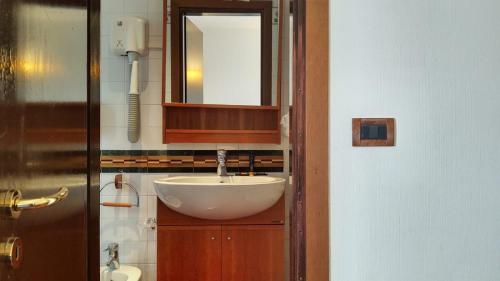 ein Bad mit einem Waschbecken und einem Spiegel in der Unterkunft HG Hotel Italia in Brusson