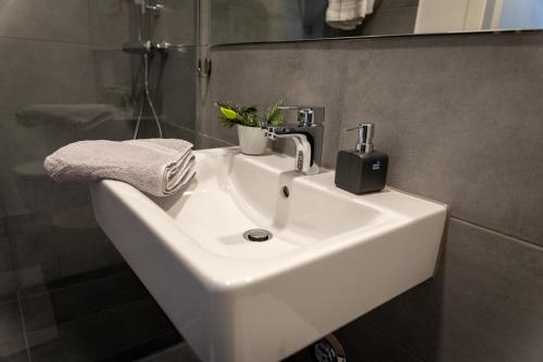 - Baño con lavabo blanco y ducha en Arbio I Duxen Apartments Hagenbeck Zoo en Hamburgo