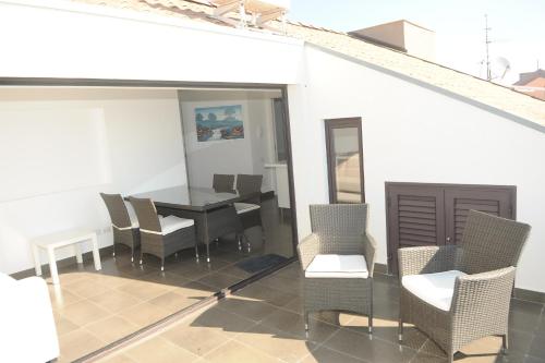 a dining room with a table and chairs at The Roof On The Sea in Fondachello