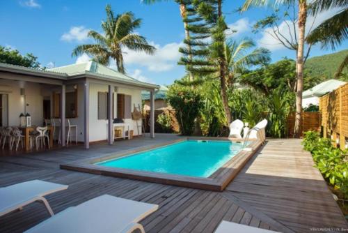 a backyard with a swimming pool and a house at Villa Laucaly Orient Bay in Orient Bay