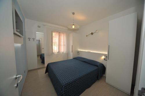 a bedroom with a blue bed in a white room at Casa Campanella Resort in Capoliveri
