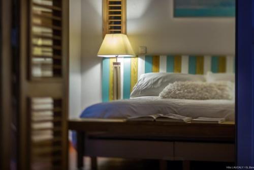 a bedroom with a bed with a lamp on it at Villa Laucaly Orient Bay in Orient Bay