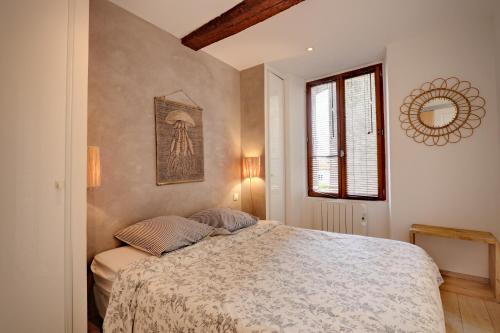 un dormitorio con una cama y una ventana en Le ST Tropez, en Saint-Tropez
