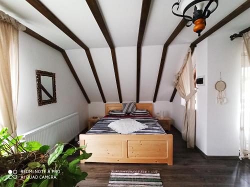 a bedroom with a bed and a ceiling with beams at Casa Lucia in Dămuc