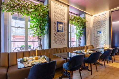 um restaurante com mesas, cadeiras e janelas em Lx Boutique Hotel em Lisboa