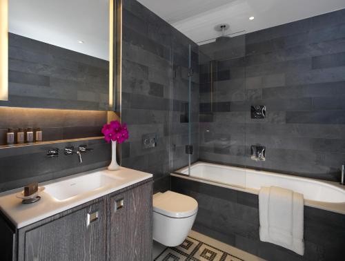 a bathroom with a sink and a tub and a toilet at Flemings Mayfair - Small Luxury Hotel of the World in London
