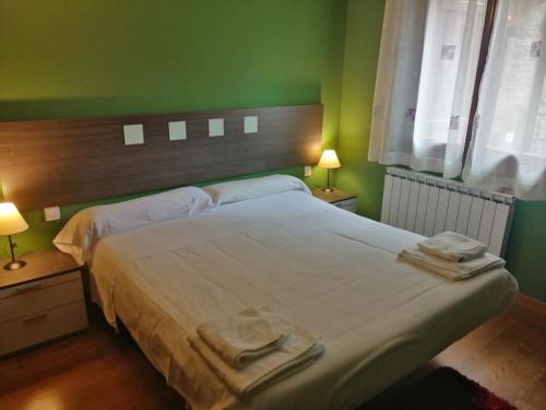 a bedroom with a large bed with two towels on it at Los Altos de Escarrilla - tucasaenlospirineos in Escarrilla