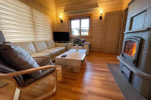 a living room with a couch and a fireplace at Dore in Lielvārde