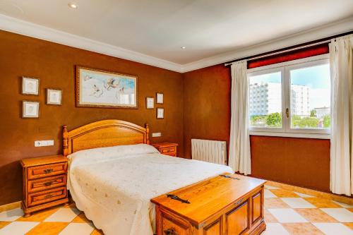 - une chambre avec un lit en bois et une fenêtre dans l'établissement Villa SANFORA Alcudia, à Port d'Alcúdia