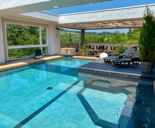 a swimming pool in a house with a patio at Admiral Park Hotel by Falco D'Oro Hotels in Zola Predosa