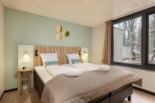 - une chambre avec 2 lits et une grande fenêtre dans l'établissement Center Parcs Heijderbos Limburg-Weeze, à Heijen