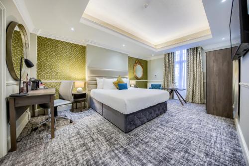 a hotel room with a bed and a desk at Grosvenor Hotel in Stratford-upon-Avon