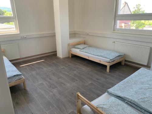 a room with two beds and two windows at Ubytování Litoměřická s parkovištěm in Česká Lípa