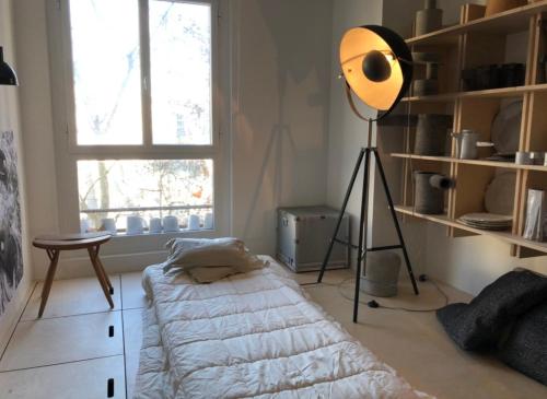 Cette chambre comprend un lit et une lampe. dans l'établissement duplex top central Marais, à Paris