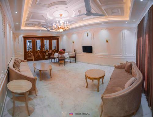a living room with a couch and tables and a television at Arish Luxury Suites in Skardu