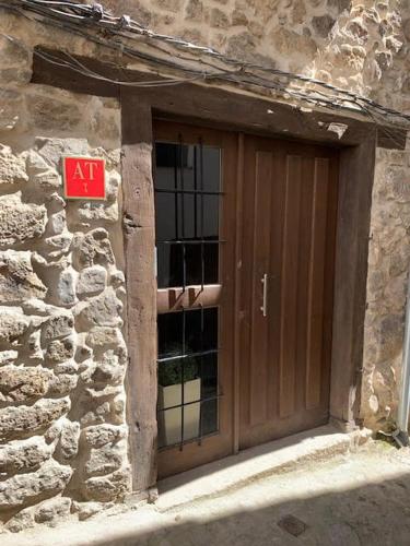 a door of a stone building with a sign on it at Aptos La Ceja, El Trampal y El Reloj by CASA BOLDO in Candelario