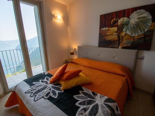 1 dormitorio con cama y ventana grande en Van Gogh - beautiful lake Iseo view and swimming pool, en Parzanica