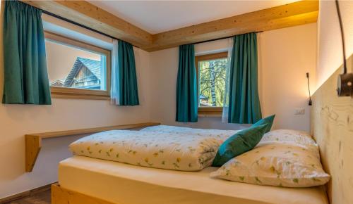 a bedroom with a bed and two windows at Chalet Fisti in La Villa