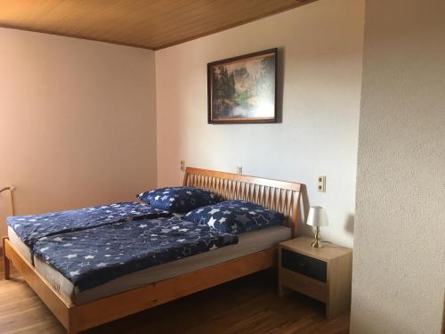 a bedroom with a bed and a picture on the wall at Rhöner Sternenhimmel FeWo 1 und 2 in Frankenheim