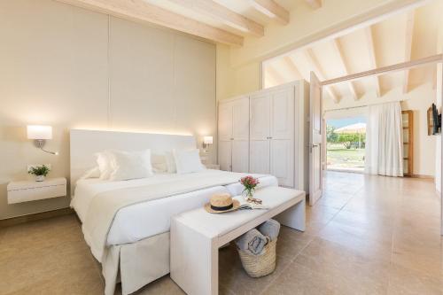 a bedroom with a large white bed and a table at Hotel Sa Franquesa Nova in Vilafranca de Bonany