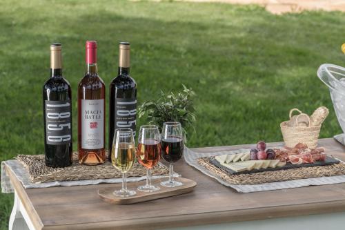 a table with three bottles of wine and wine glasses at Hotel Sa Franquesa Nova in Vilafranca de Bonany