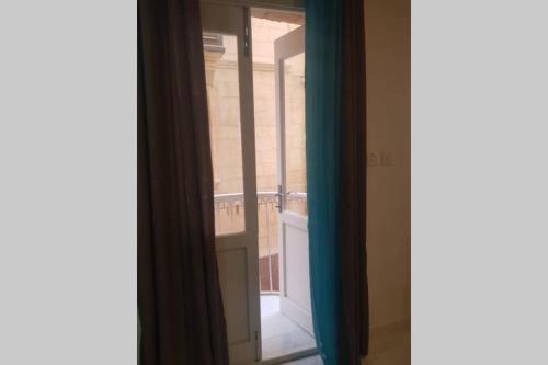 een open raam met uitzicht op een balkon bij Valletta Malta in Il-Furjana