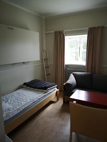 a bedroom with a bed and a chair and a window at Åredalens fjällgård in Järpen