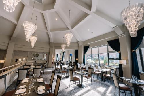 a restaurant with tables and chairs and chandeliers at Roe Valley Resort in Limavady