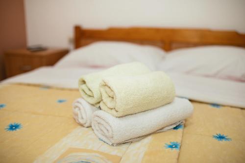 a pile of towels sitting on top of a bed at Pansion Čirjak in Sveti Filip i Jakov