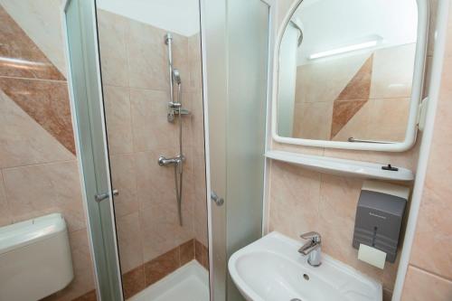 a bathroom with a shower and a sink and a toilet at Pansion Čirjak in Sveti Filip i Jakov